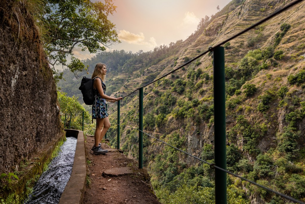 Wandelaar op levadapad langs berghelling op Madeira, tijdens 22-35ers reis Madeira & Portugal.