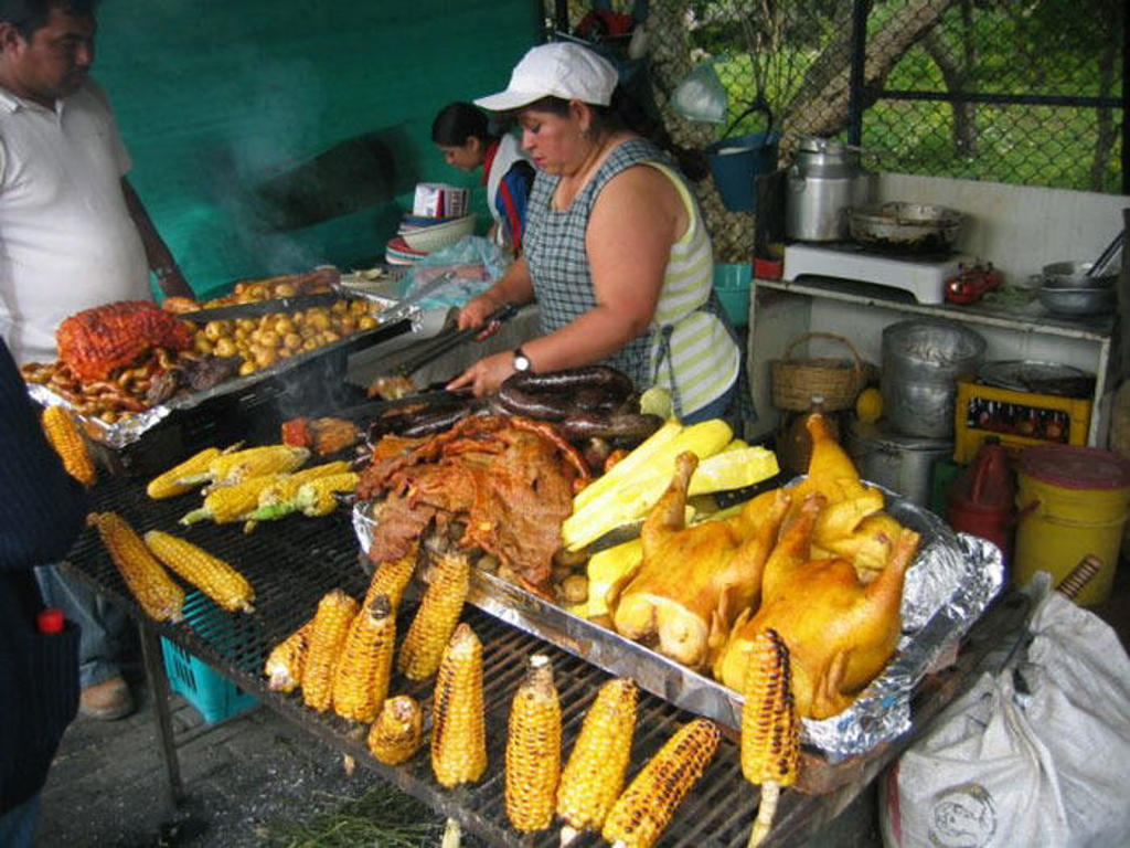 Straatbarbecue met gegrilde kip, maïs en vlees tijdens familiereis Colombia.