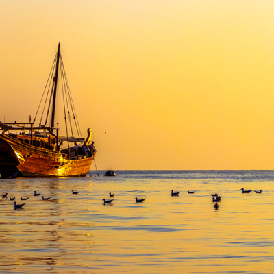 Traditionele dhow bij zonsondergang op zee in Oman, tijdens de groepsrondreis Oman en Dubai.