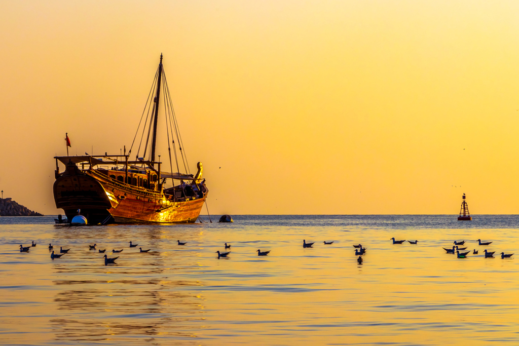 Traditionele dhow bij zonsondergang op zee in Oman, tijdens de groepsrondreis Oman en Dubai.