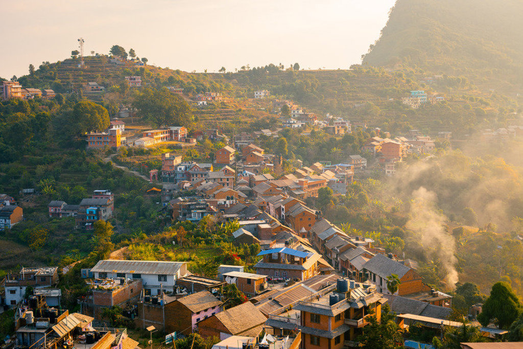 Heuveldorp met terrassen en huizen langs de Annapurna Basecamp-trek in Nepal, bij zonsopkomst.