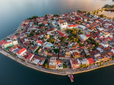 het eilandstadje Flores aan het Petén Itzá-meer in Guatemala, met kleurrijke huizen en kerk.