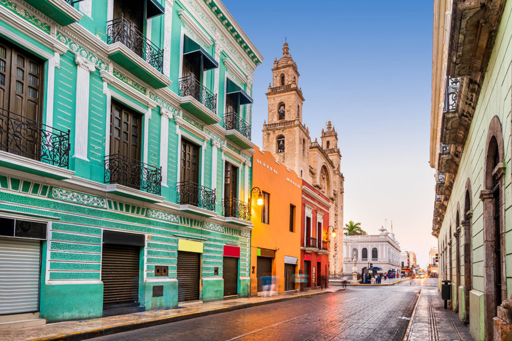 Kleurrijke koloniale straat met kathedraal in Mérida, Mexico, tijdens een familiereis.