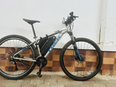Zijaanzicht van een e-bike met accu, geschikt voor een fietsreis huren.