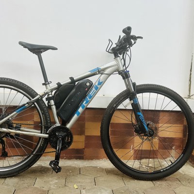 Zijaanzicht van een e-bike met accu, geschikt voor een fietsreis huren.
