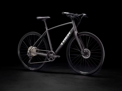 Zwarte Trek mountainbike met schijfremmen op donkere achtergrond.