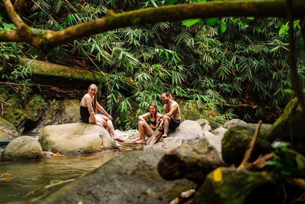22-35ers ontspannen aan een rivier in het regenwoud van Costa Rica tijdens een groepsrondreis.