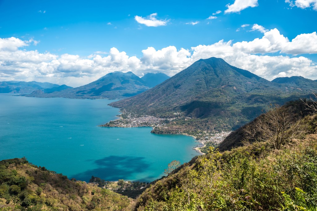 Uitzicht op het Atitlánmeer met vulkanen en dorpjes aan de oever in Guatemala.