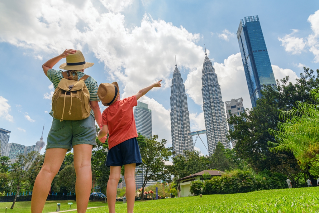 Ouder en kind kijken naar de Petronas Twin Towers in Kuala Lumpur tijdens een familiereis Maleisië.