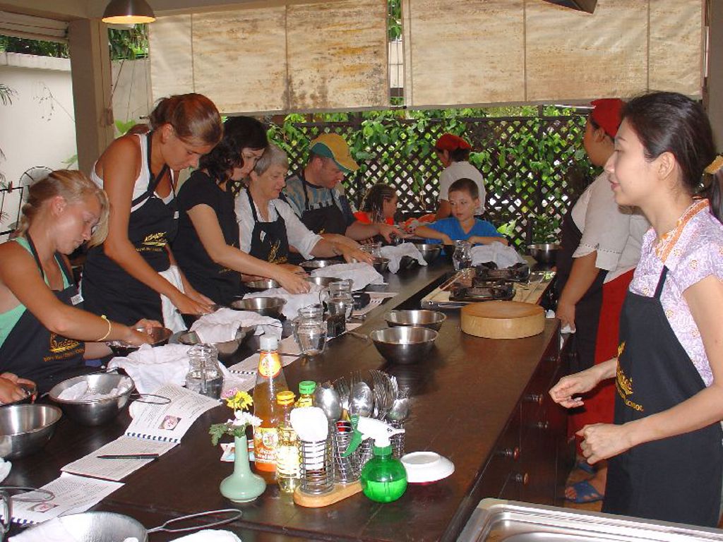 Kookworkshop tijdens familiereis Thailand Noord en Zuid, met deelnemers die samen gerechten bereiden.
