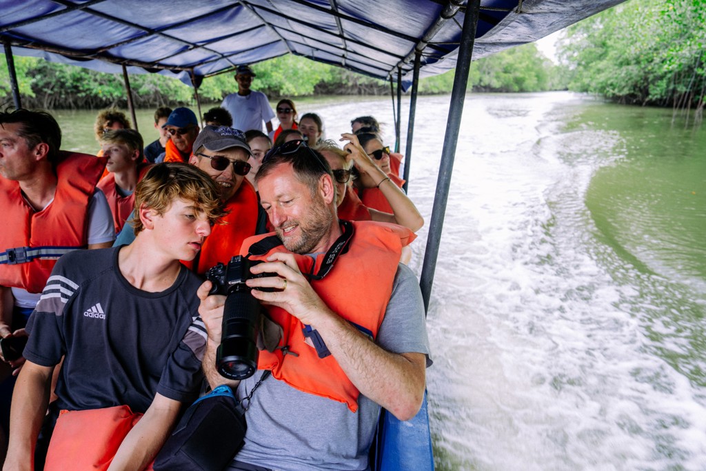Gezin op boottocht door de groene mangroven in Costa Rica tijdens een familiereis.