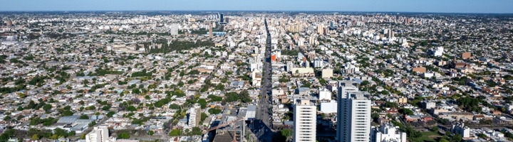 Panoramisch uitzicht over Córdoba met een lange hoofdstraat en moderne hoogbouw onder een heldere blauwe lucht.