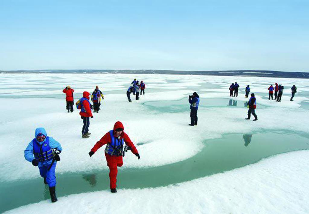 Reizigers wandelen over een gletsjerlandschap tijdens de groepsrondreis Spitsbergen, Groenland en IJsland.