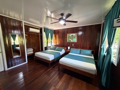 Slaapkamer met twee tweepersoonsbedden in Valverde Lodge, Costa Rica.