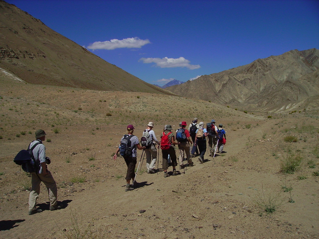 Wandelgroep met rugzakken trekt door het berglandschap van Ladakh tijdens groepsrondreis India Spiti & Ladakh.