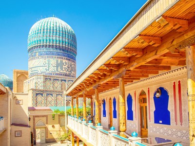 Blauw betegelde koepel en binnenplaats van een madrassa in Oezbekistan, onderdeel van de Route Oezbekistan.