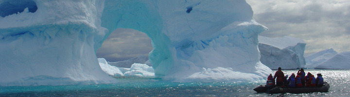 Zodiacboot met reizigers langs ijsbergen in Antarctica tijdens een rondreis.
