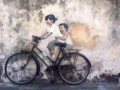 Muurschildering van twee kinderen op een fiets in George Town, Penang, tijdens de Route Maleisië.