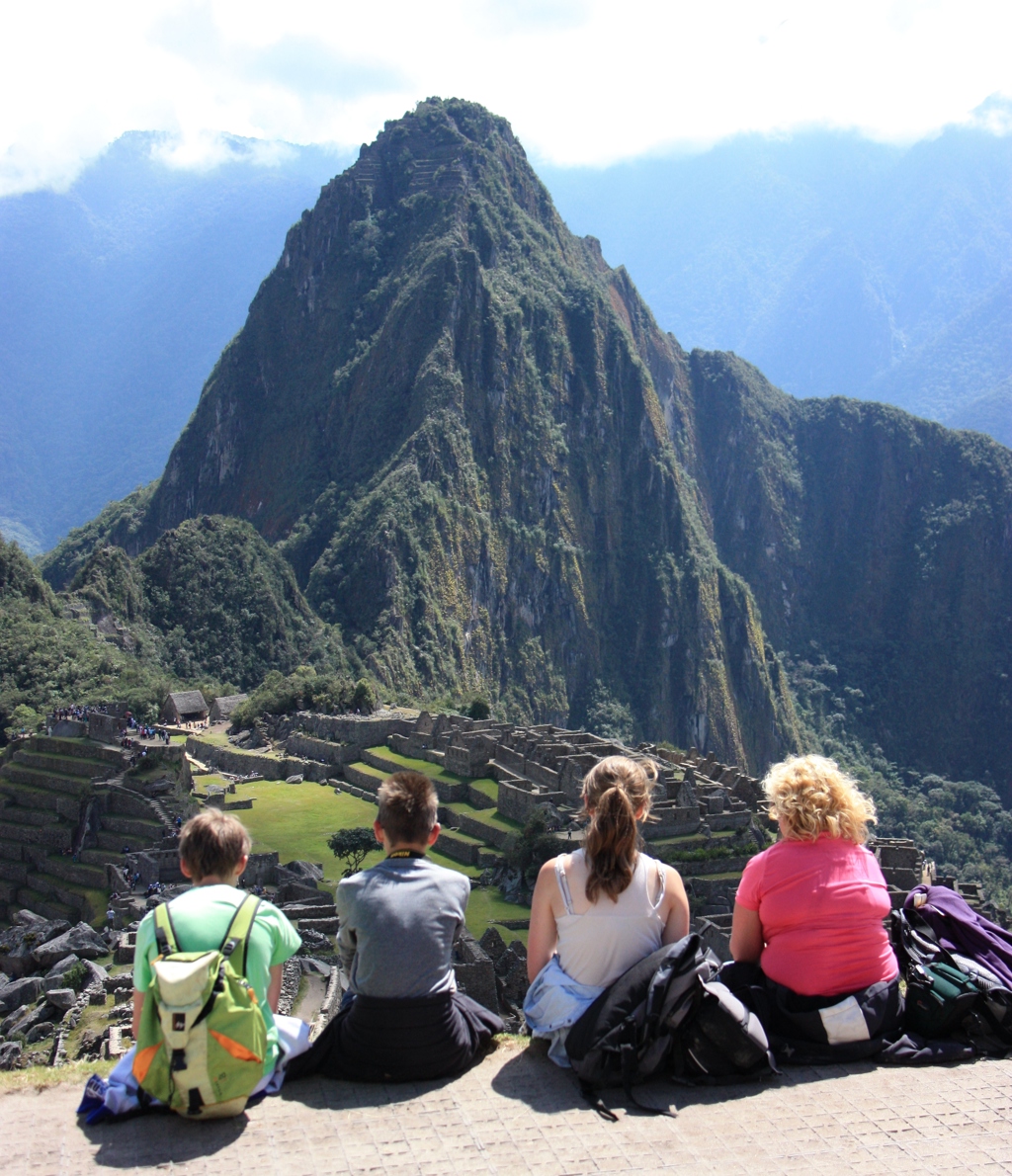 Gezin kijkt uit over Machu Picchu en de Huayna Picchu-berg tijdens een familiereis Peru.