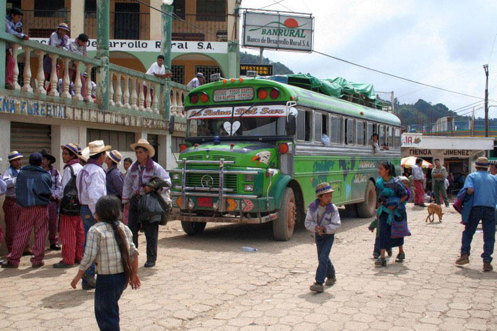 Groene chickenbus op een marktplein in Guatemala tijdens een familiereis Guatemala en Belize.
