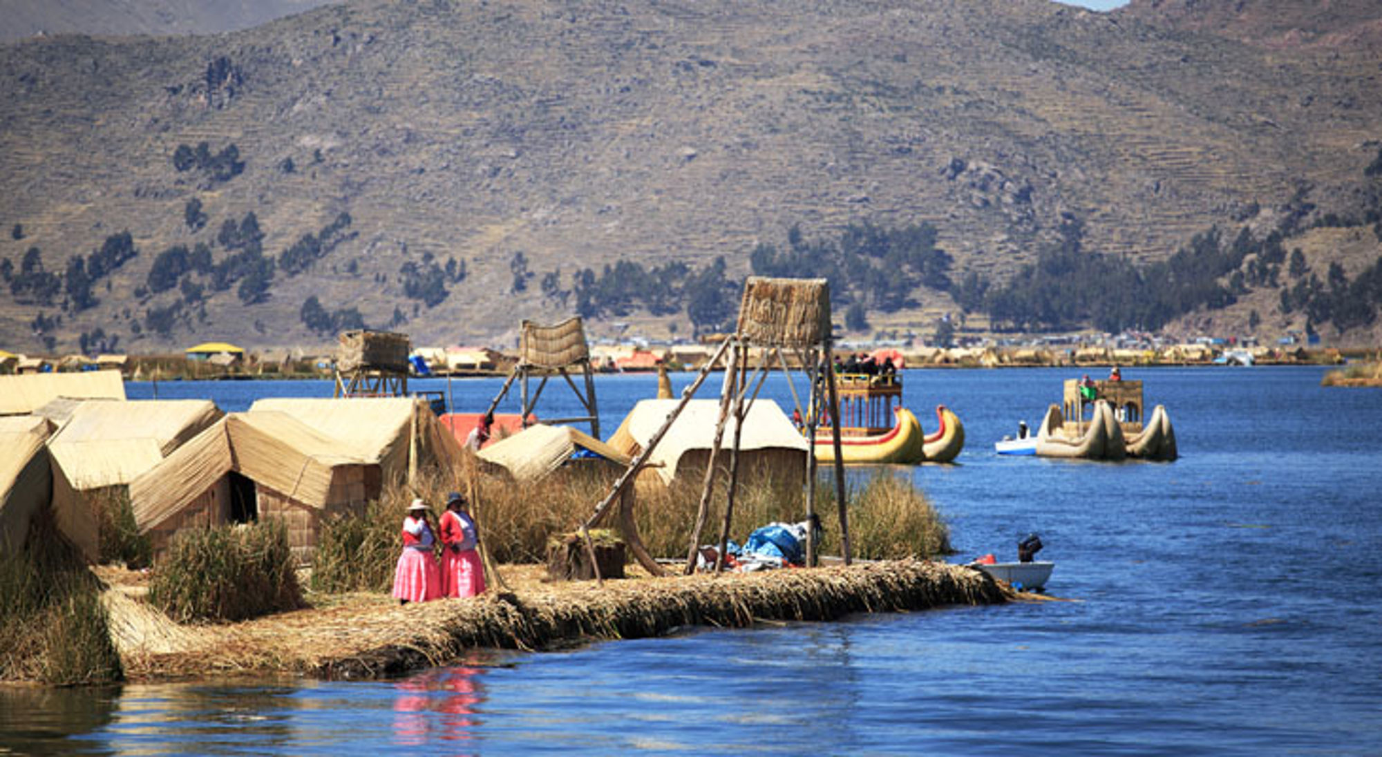 Rieteilanden en boten op het Titicacameer bij de Uros-eilanden in Peru.