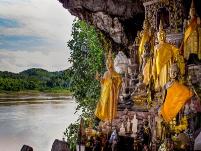 Gouden boeddhabeelden in een grot aan de Mekong-rivier tijdens de route Laos & Cambodja.