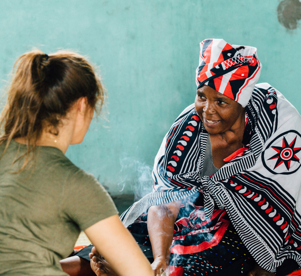 Vrouw in traditionele Eswatini-kleding in gesprek met reiziger tijdens groepsrondreis Noordelijk Zuid-Afrika en eSwatini.