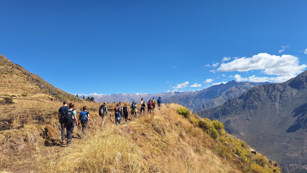 Gezin en andere reizigers wandelen in de Andes in Peru tijdens een familiereis, met uitzicht op bergen en valleien.