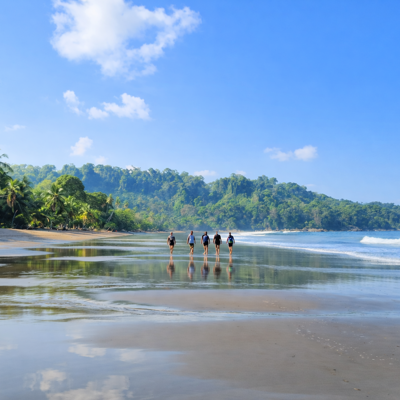 Groep reizigers wandelt over een tropisch strand in Costa Rica tijdens een 22-35ers reis.