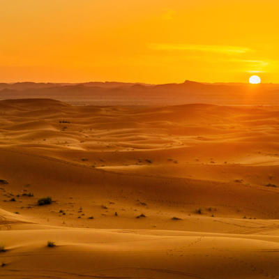 Zonsondergang boven zandduinen in de Sahara tijdens de premium groepsrondreis door Marokko.