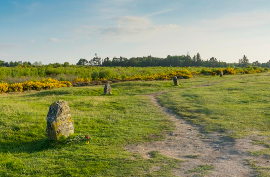 Wandelpad door heidelandschap in de Schotse Hooglanden met staande stenen langs de route.