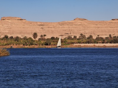 Zeilboot op de Nijl met palmbomen en rotsplateau langs de oever, Route Egypte dag 7.