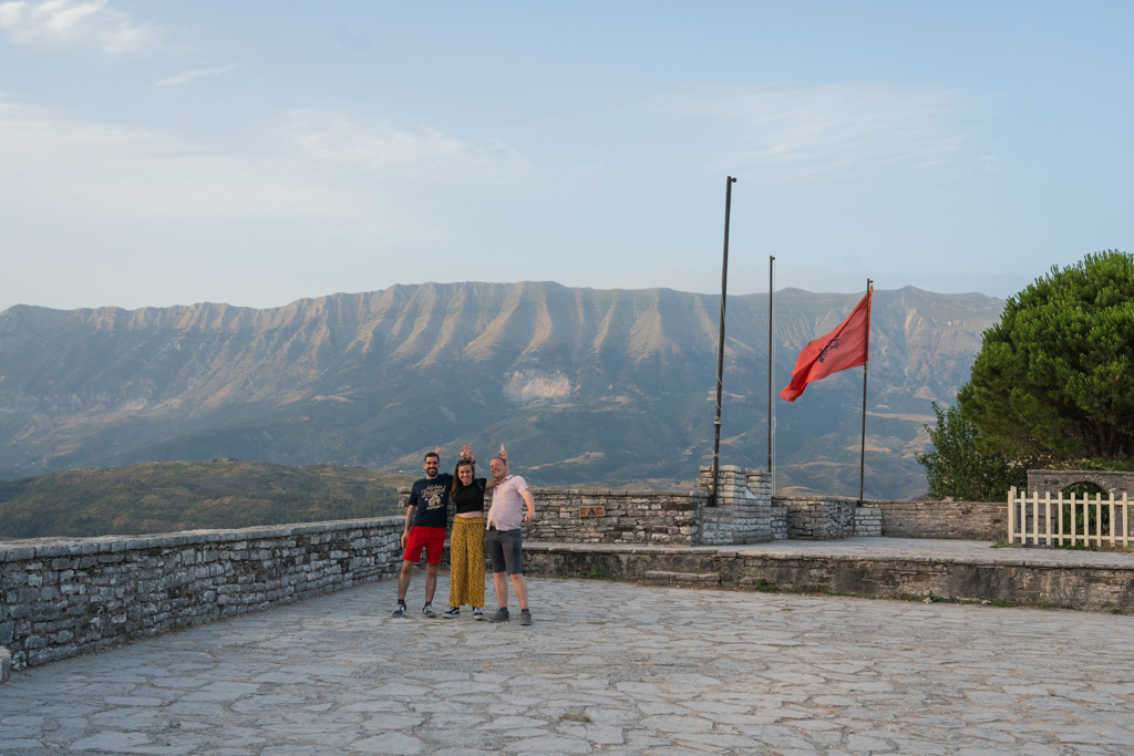 Reizigers op uitkijkpunt met Albanese vlag en uitzicht op de bergen tijdens 22-35ers reis Albanië.