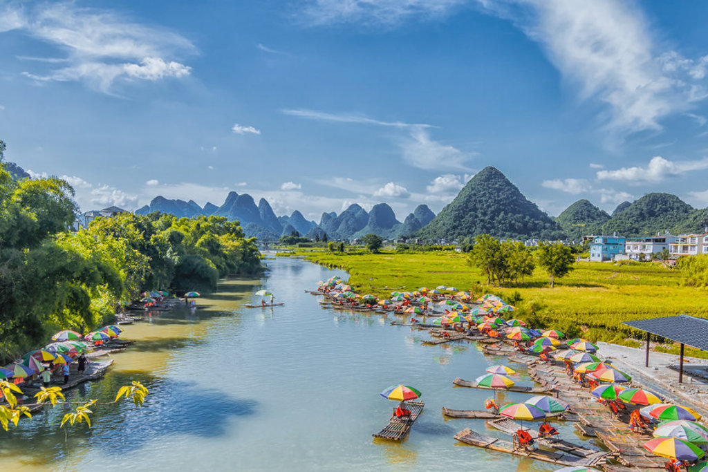 Bamboevlotten met kleurrijke parasols op de Yulong-rivier bij Yangshuo, tijdens groepsrondreis China.