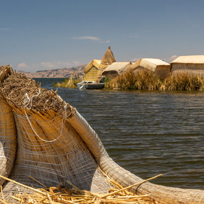Rieten boot en drijvende rieteilanden op het Titicacameer in Peru.