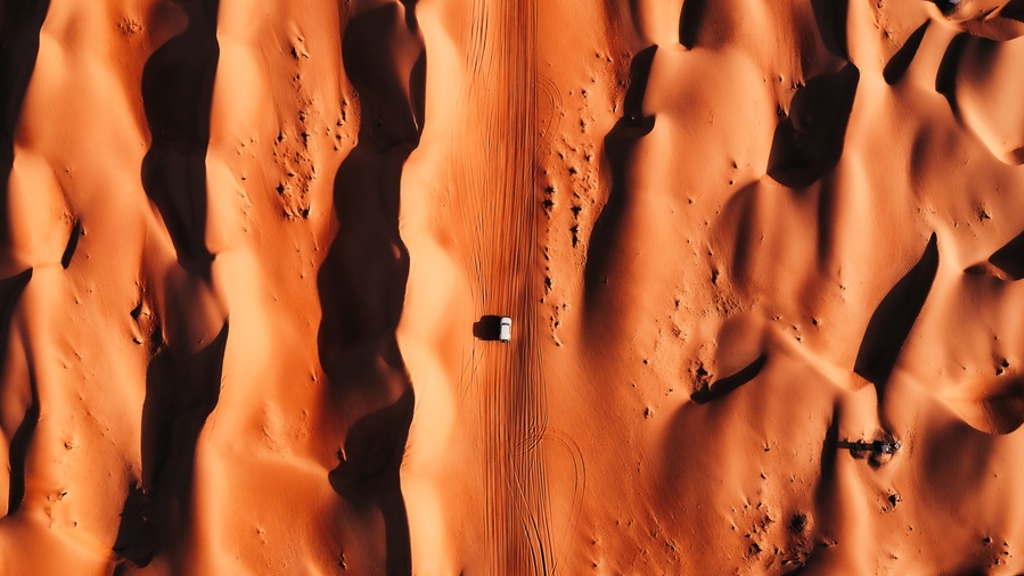 4x4 rijdt door hoge zandduinen in Oman tijdens groepsrondreis Oman en Dubai.