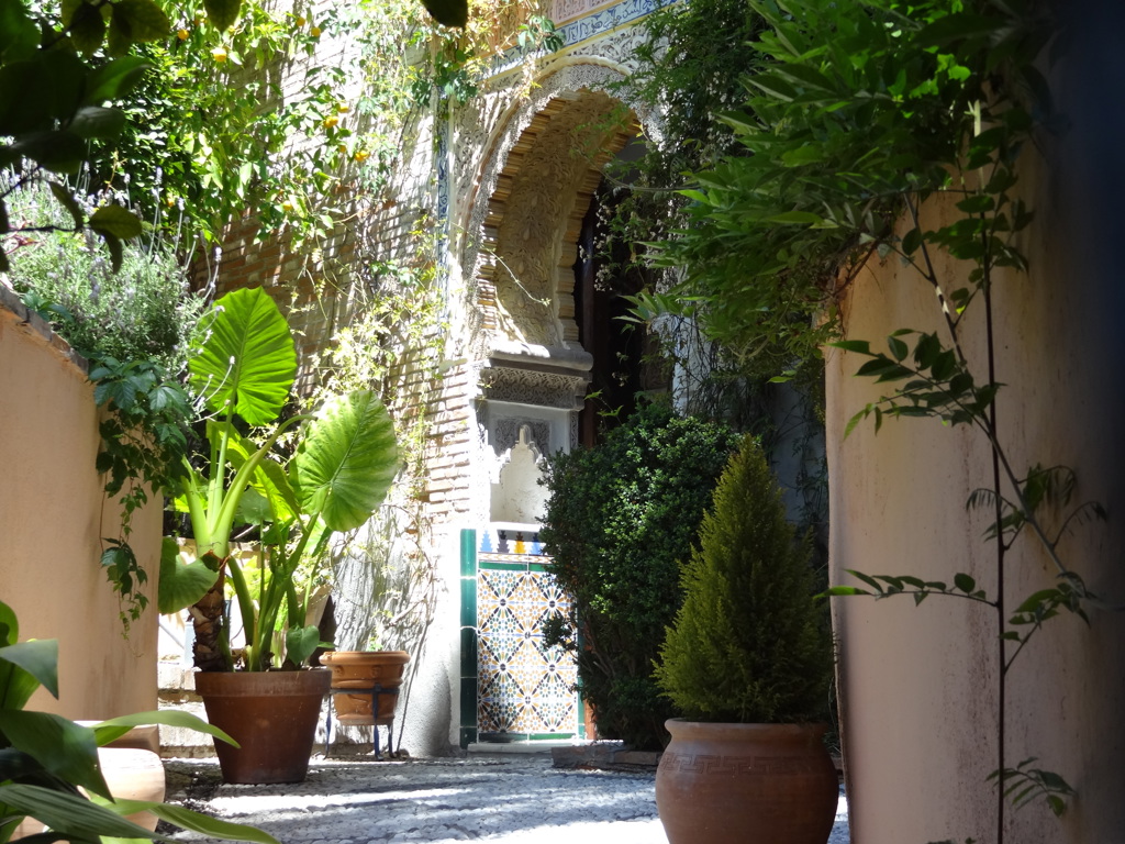 Zonnige patio met Moorse boog en kleurrijke tegels in Andalusië, Spanje.