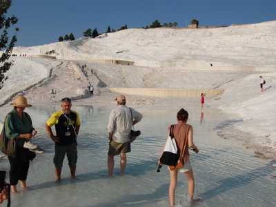 Bezoekers bij de kalkterrassen en thermale baden van Pamukkale, een hoogtepunt op de route door Turkije.