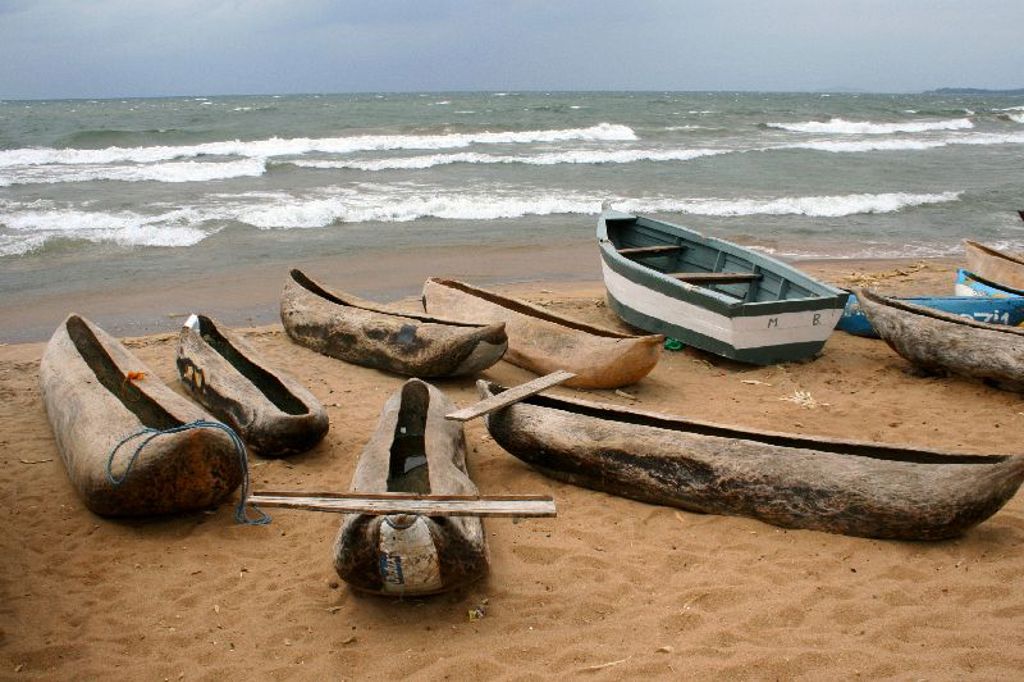 Houten visserskano’s en een boot op het strand aan het Malawimeer tijdens groepsrondreis Zambia, Malawi en Tanzania.