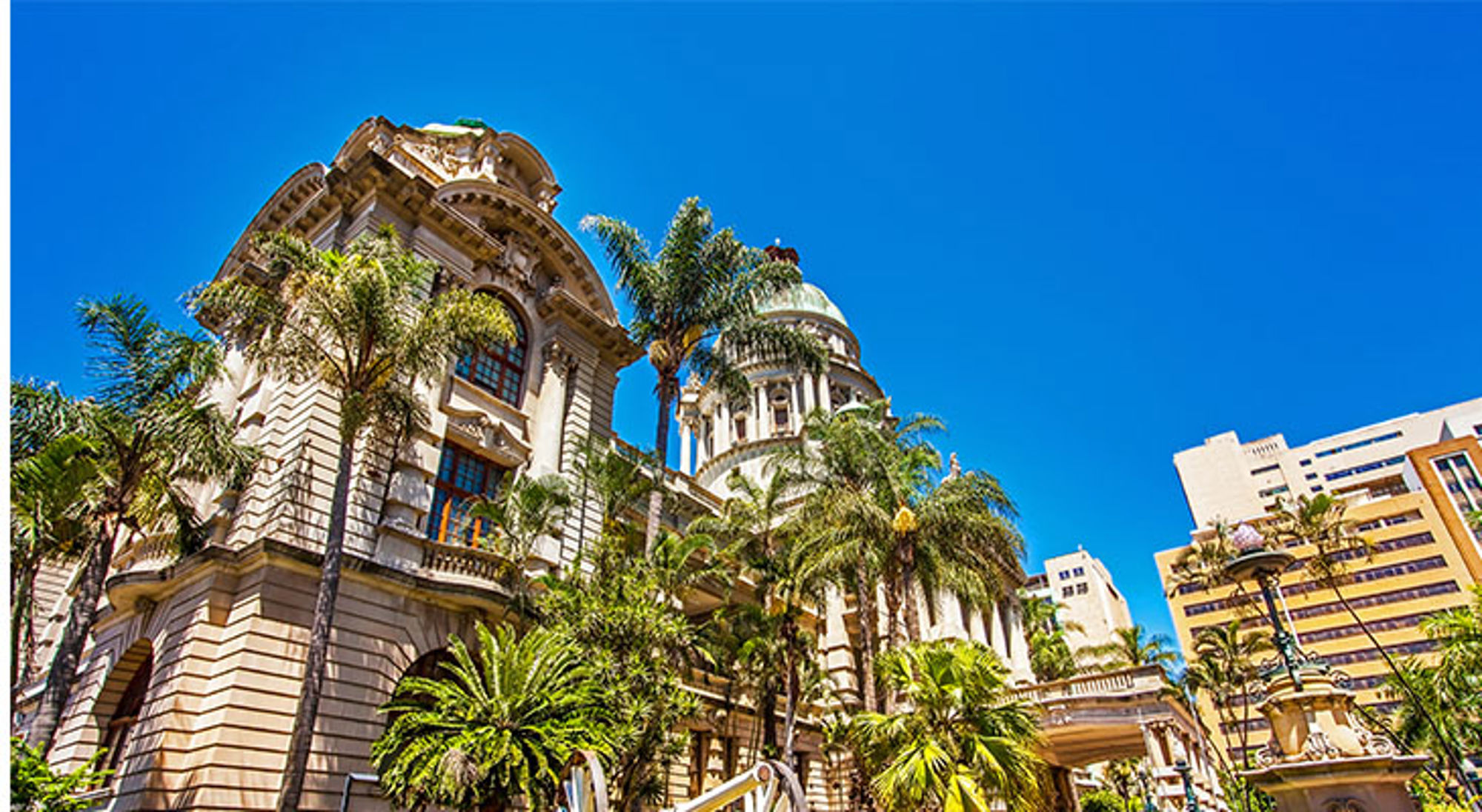 Palmbomen bij het Monte Carlo Casino in Monte Carlo, Monaco, onder een strakblauwe lucht.