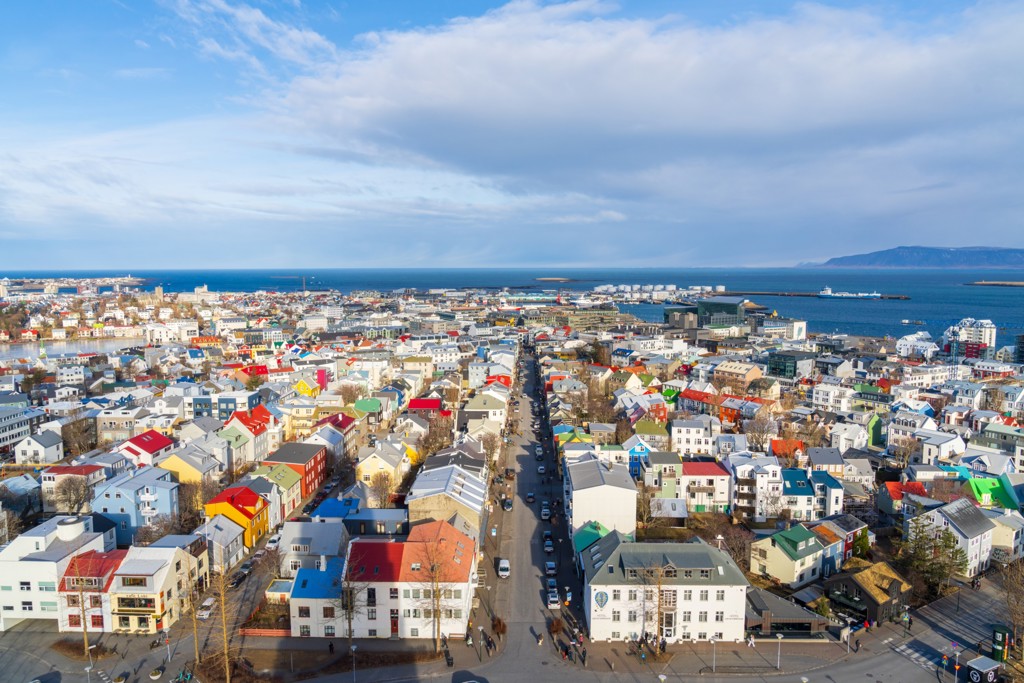 Uitzicht over het kleurrijke centrum van Reykjavik met de haven en zee, tijdens een 22-35ers reis IJsland.