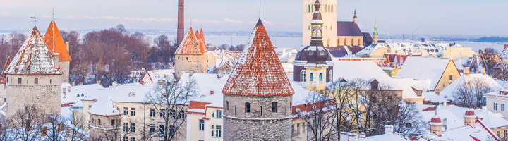 Besneeuwd uitzicht op de oude binnenstad van Tallinn, Estland, met middeleeuwse torens en kerken.