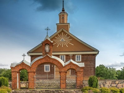 Houten kerk met bakstenen poort in de Baltische Staten-route.