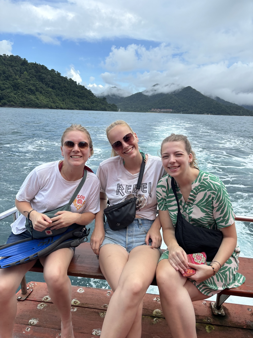 Vriendinnen op een boottocht met uitzicht op groene bergen tijdens de 22-35ers reis Thailand, Laos & Cambodja.