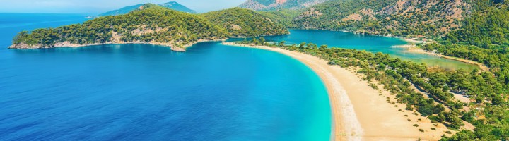 Panoramisch uitzicht op Blue Lagoon en het strand van Ölüdeniz aan de Turkse Rivièra, met turquoise zee en bergen.