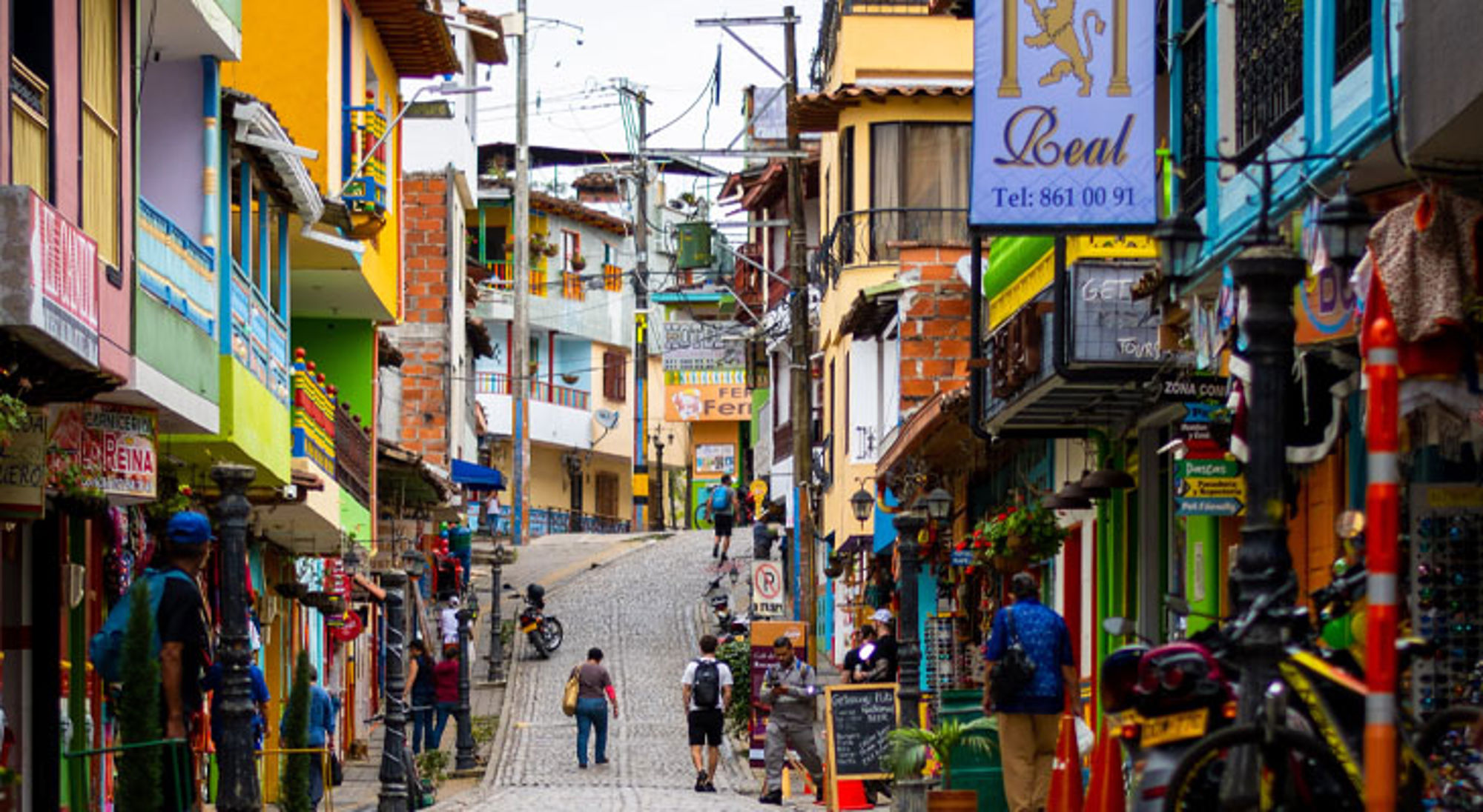 Kleurrijke straat Guatapé Kleurrijke straat met winkels en wandelaars in een Colombiaanse stad.