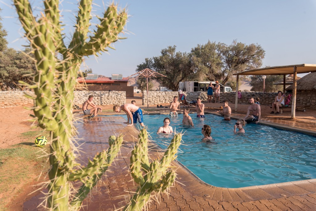 Gezinnen ontspannen in een zwembad bij een lodge in Namibië tijdens familiereis Namibië, Botswana en Zimbabwe.