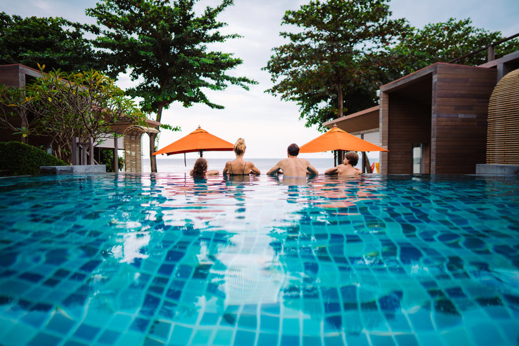 Gezin ontspant in een infinitypool bij een strandresort in Thailand tijdens de 15-daagse familiereis Thailand Hoogtepunten.