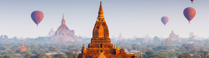 Pagodes in Bagan, Myanmar, met luchtballonnen boven de tempelvlakte bij zonsopkomst.