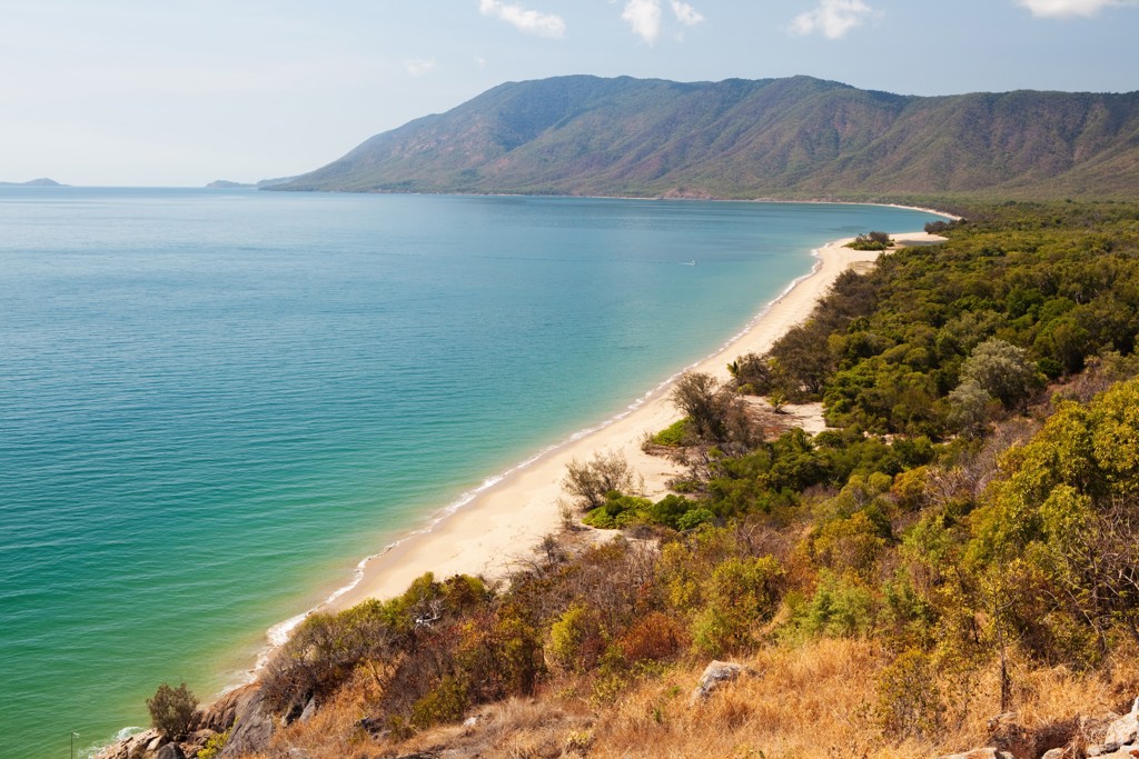 Kustlijn met wit zandstrand en helderblauw water in Australië tijdens een groepsrondreis van Sydney naar Darwin.